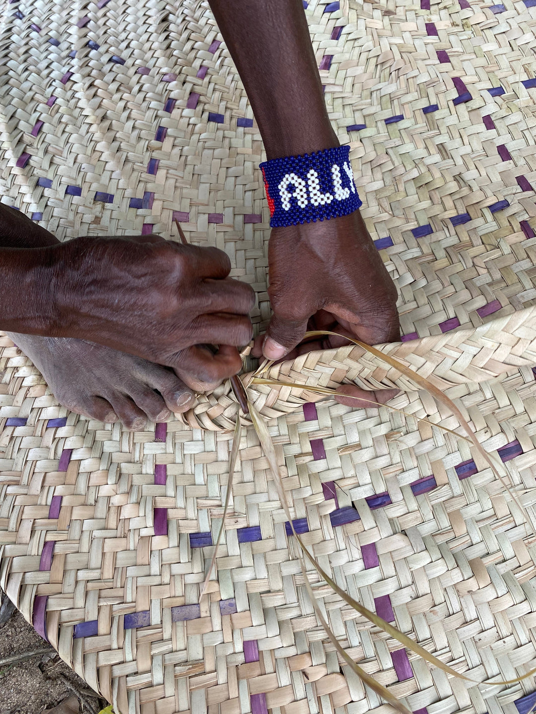 Fairtrade artisan partner weaving a basket.
