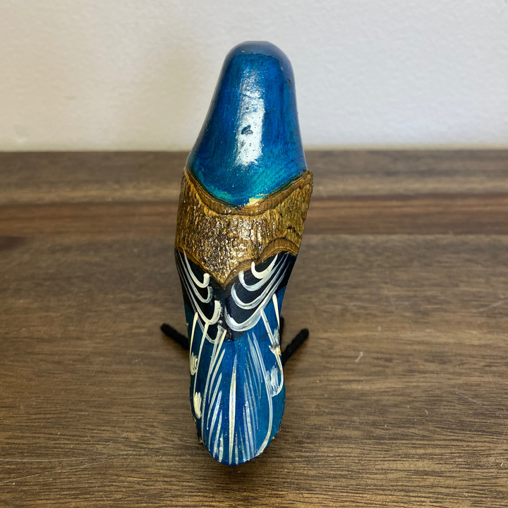 Back view of hand painted wooden bluebird ornament, showing carved feather details and natural wood grain.