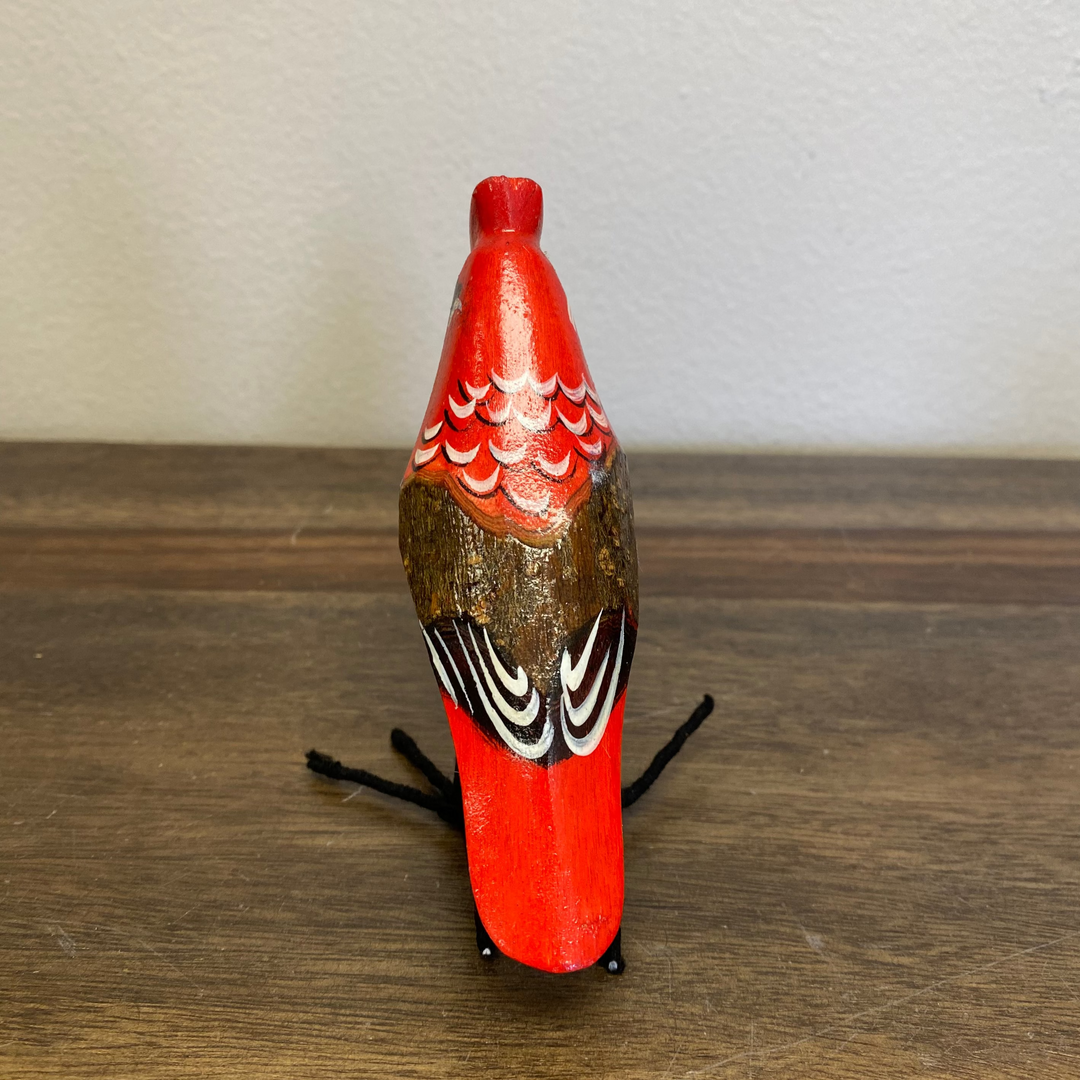 Back view of fair trade wooden cardinal ornament, hand painted in deep red with textured carving detail.