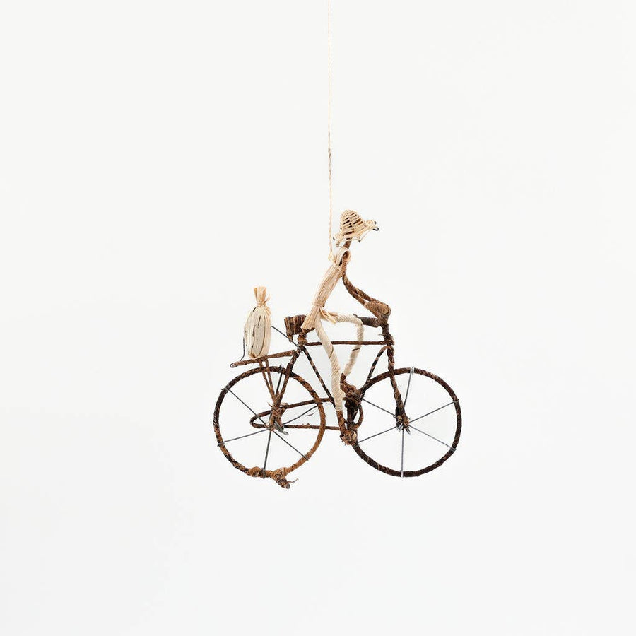 Fair trade banana leaf bicycle figurine handcrafted with metal wire frame, standing or hanging cyclist decor.