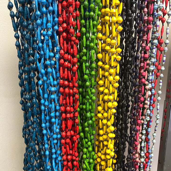 Assorted fair trade paper mache necklaces displayed on a neutral background.