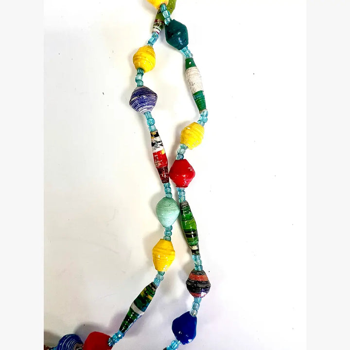 Close-up of colorful handmade paper mache necklace made from magazine paper.