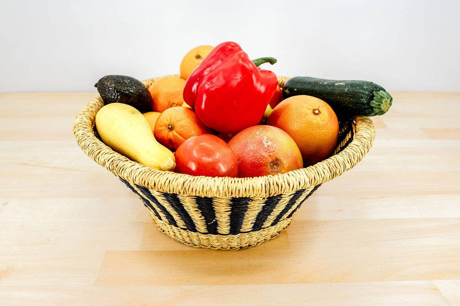 Handwoven African fruit basket with colorful, unique pattern made from dyed elephant grass.