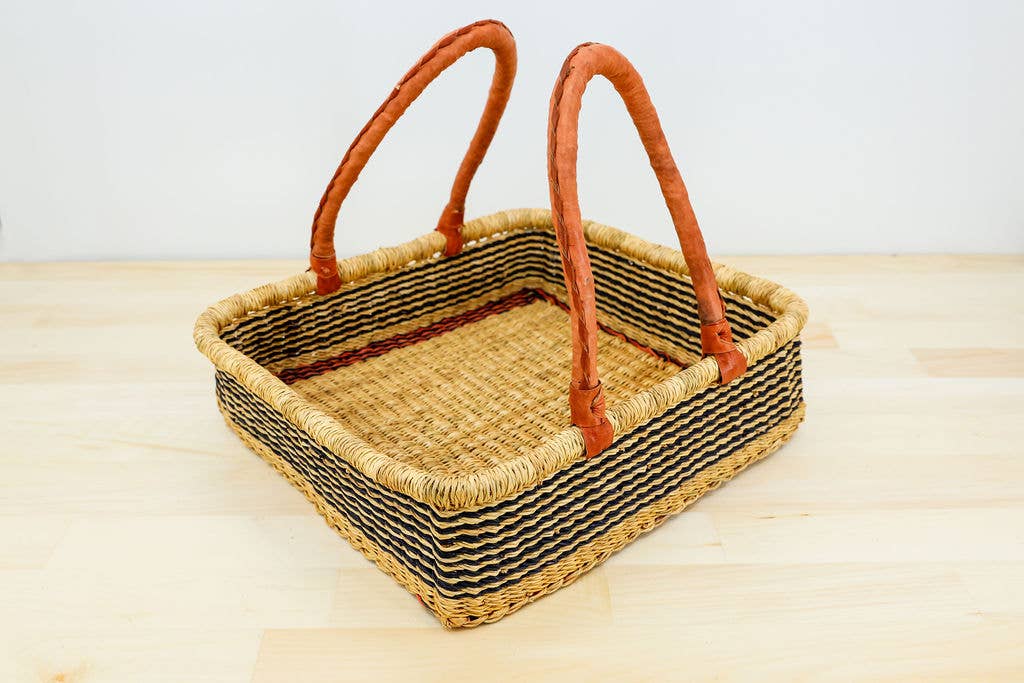 Fair trade handwoven square basket made from sustainable elephant grass with leather handles. Perfect for outdoor use like berry picking and home decor.