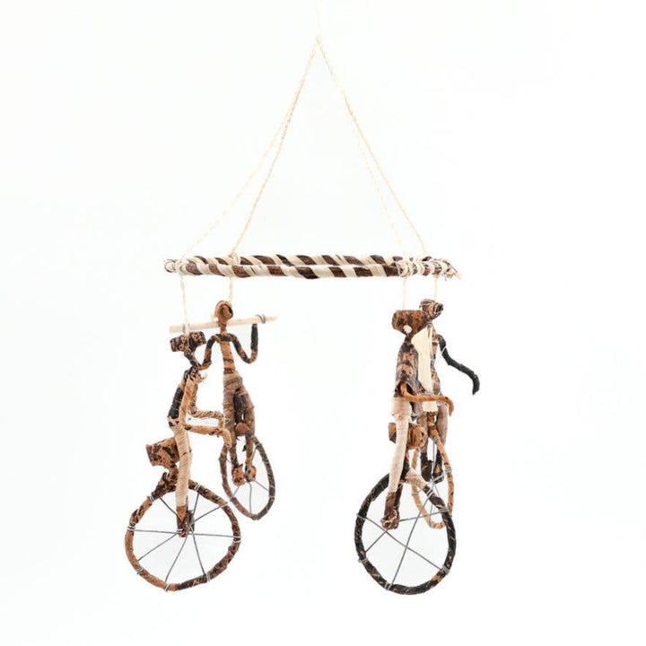 Fair trade hanging art with unicycling figures.