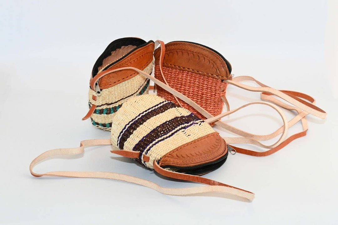 Artisan-woven natural sisal purse with adjustable leather crossbody strap.