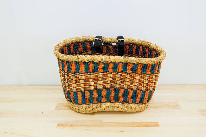 Handmade fair trade bicycle basket, crafted from hand-dyed elephant grass with leather and brass hardware.