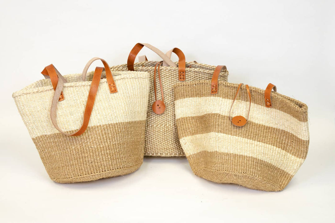 Assortment of fair trade natural woven totes in neutral colors with sustainable leather handles.