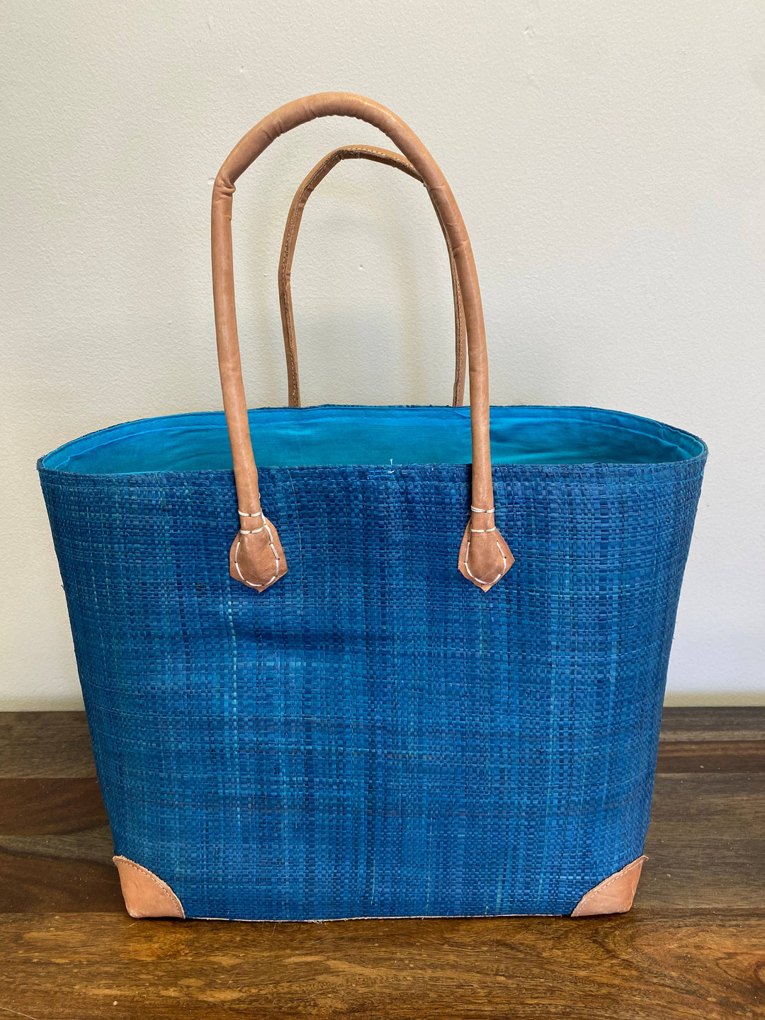 Handwoven tote bag made from palm leaf and raffia in bold blue solid color.