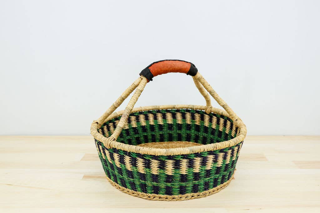 Fair trade round bread basket handwoven from elephant grass with leather handle, artisan-made in Ghana.