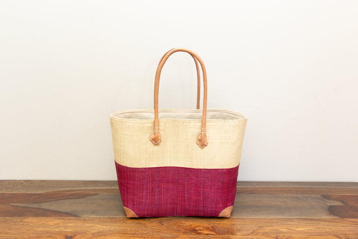Sustainable artisan bag made from raffia grass and palm leaves in two-tone pattern.