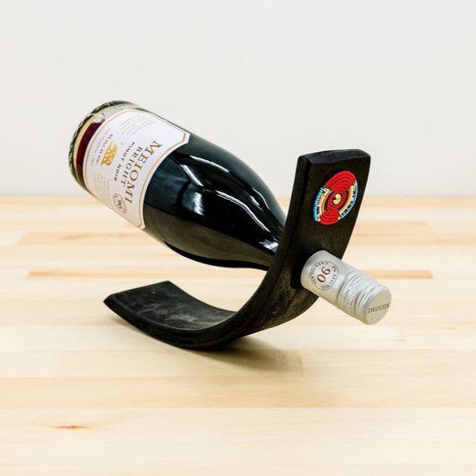 Hand-carved jacaranda wood wine bottle holder with Maasai beads.