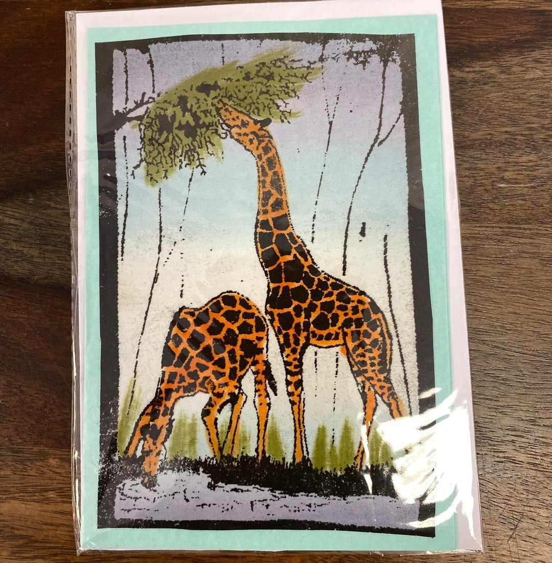 Greeting card with two giraffes under a tree on a wooden surface. Fair trade and hand-painted.