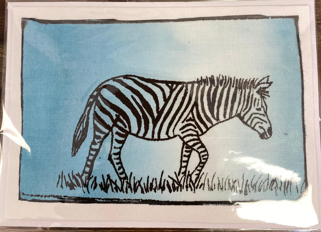 Zebra illustration on a blue background with grass at the bottom on a greeting card.