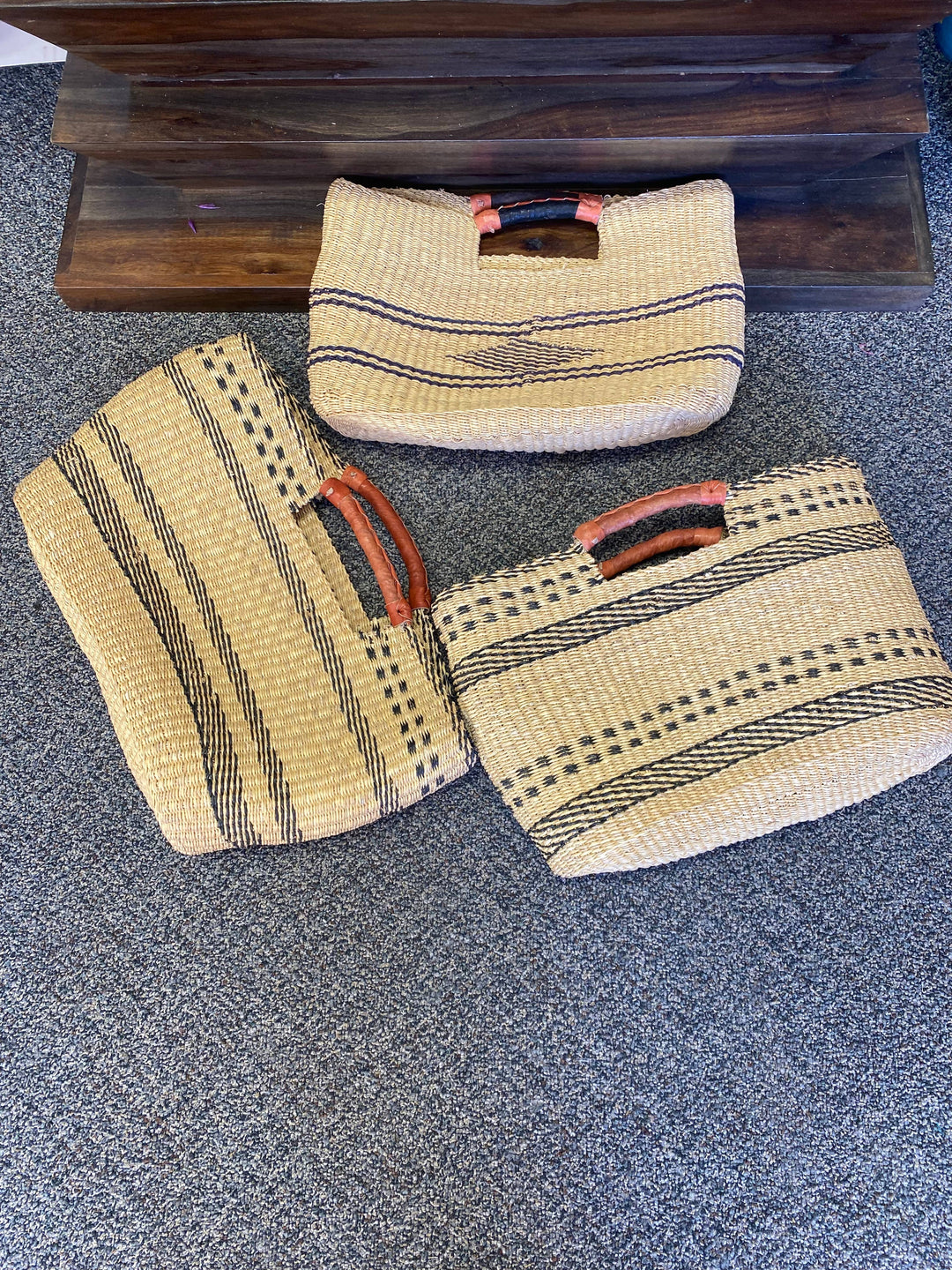 Up-cycled, hand-dyed grass clutch bag supporting Ghanaian artisans and sustainable fashion initiatives.