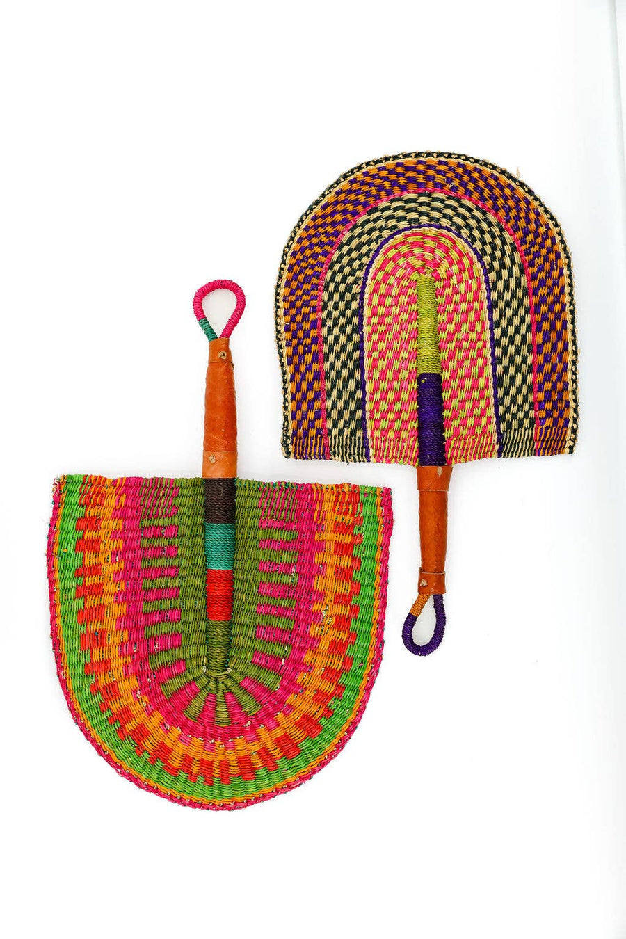Handwoven grass fan with dyed vetiver pattern and leather handle, displayed flat.
