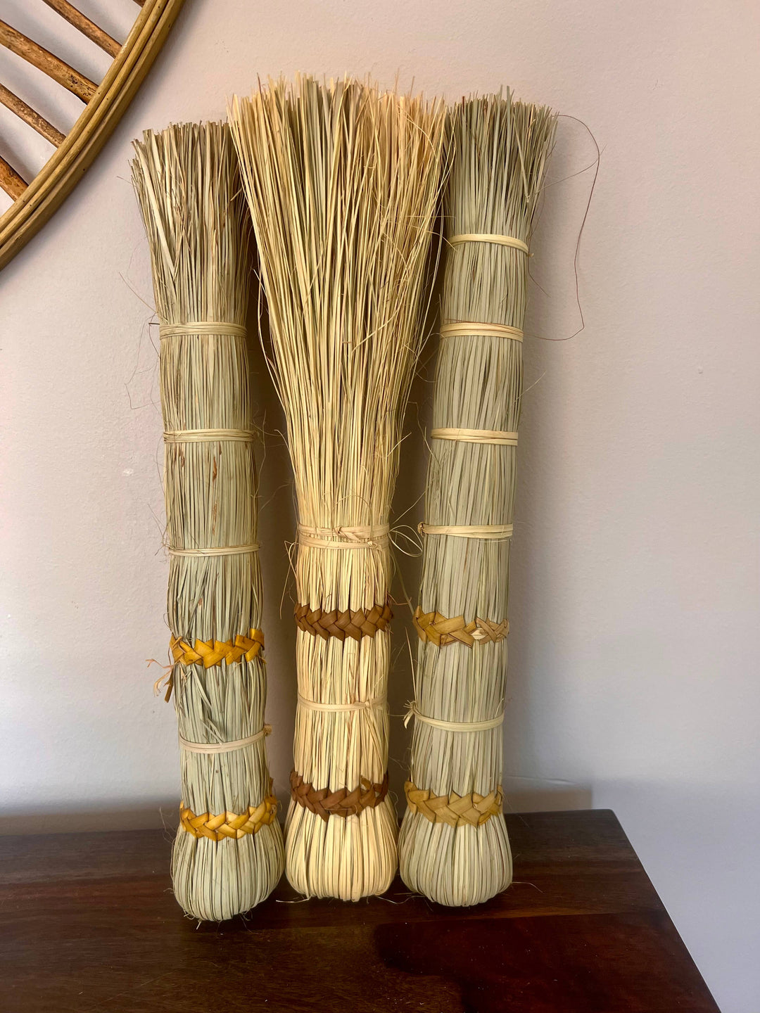 Handmade fair trade tabletop broom crafted from split palm leaves, ideal for dusting and decor.