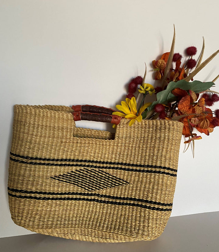 Sustainable vetiver grass clutch with leather handles, combining artisanal craftsmanship and versatile function.