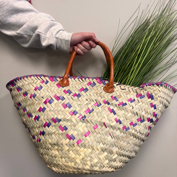 Fair trade Kikapu basket with colorful trim, crafted by Kenyan artisans from palm leaves.