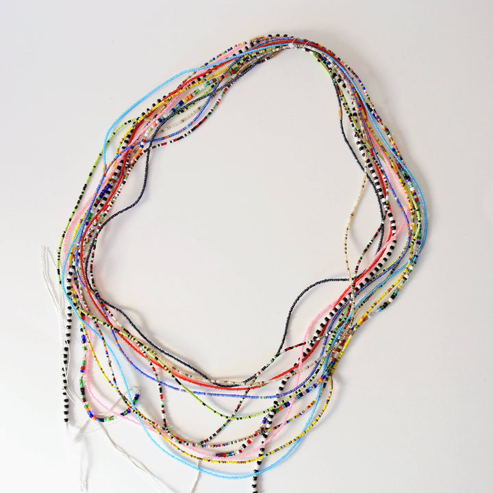Assorted waist bead strands strung on fishing wire.
