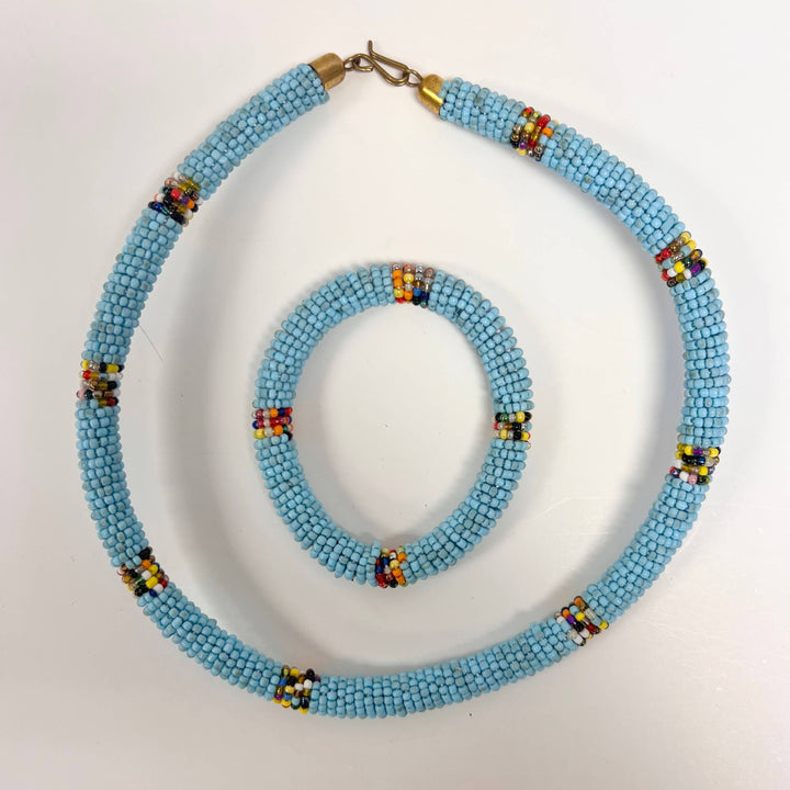 Light blue fair trade necklace and bracelet gift set supporting women artisans.