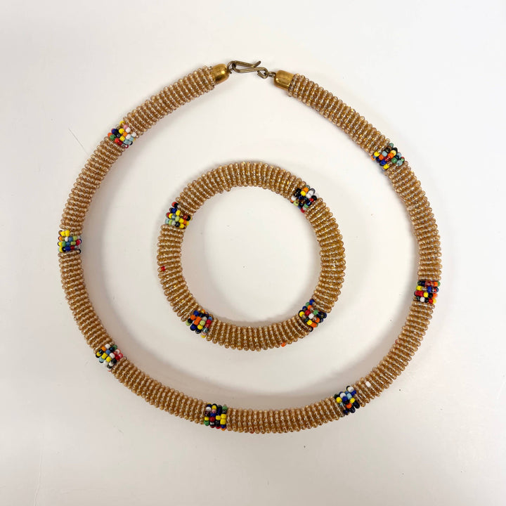 Coordinated gold necklace and bracelet made by women artisans in Kenya.