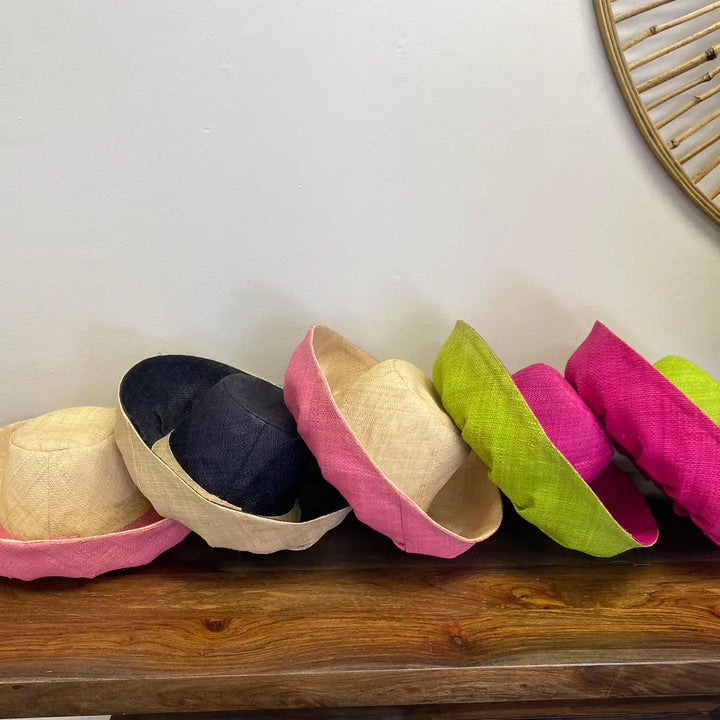 Colorful hats on a wooden surface with a plain background. Great for the beach!