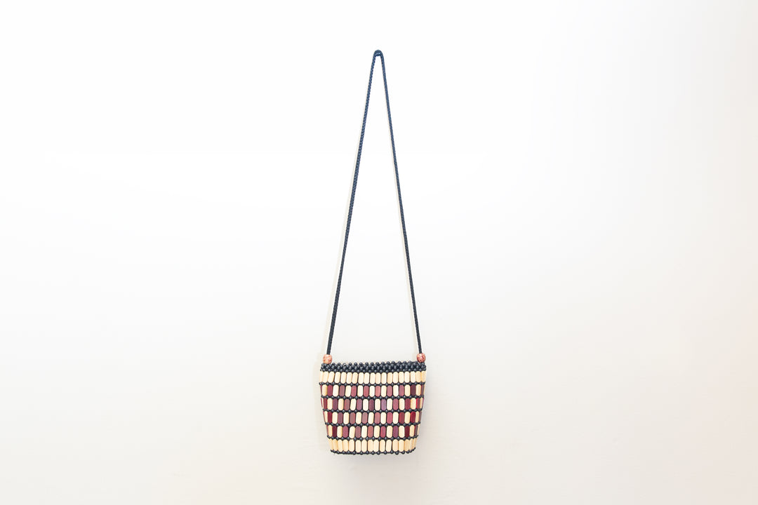 Neutral crossbody bag made out of wood pieces in Africa.