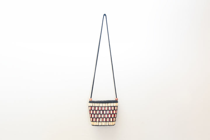 Neutral crossbody bag made out of wood pieces in Africa.