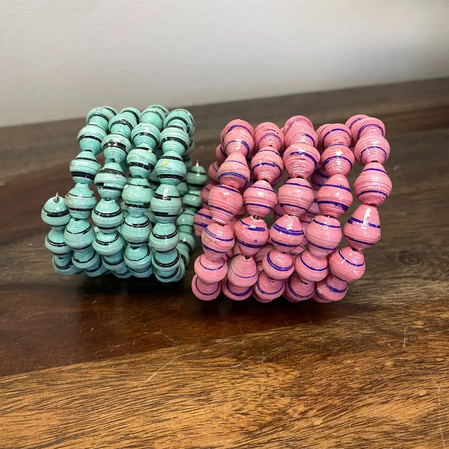 Stack of paper mache bracelets in bright, assorted hues.