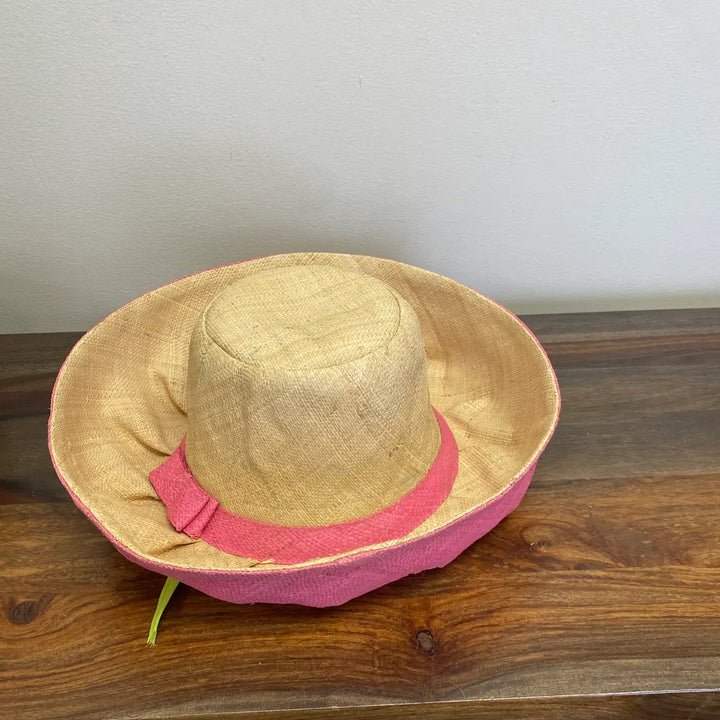 Beige straw hat with pink band on a wooden surface. Perfect hat for Sunday's at Church.