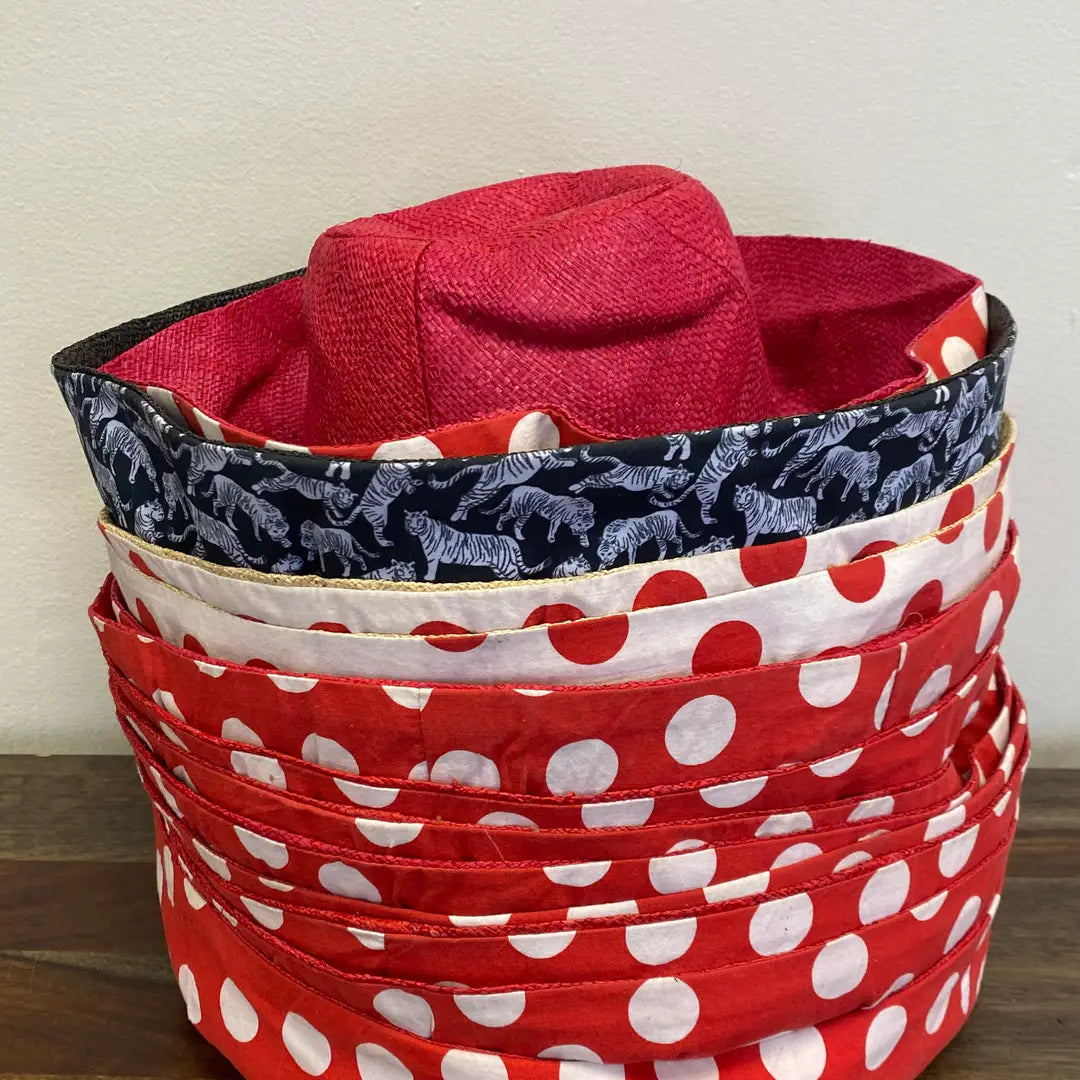 Stack of fabric baskets with red polka dot, navy with white patterns, and red with white patterns.