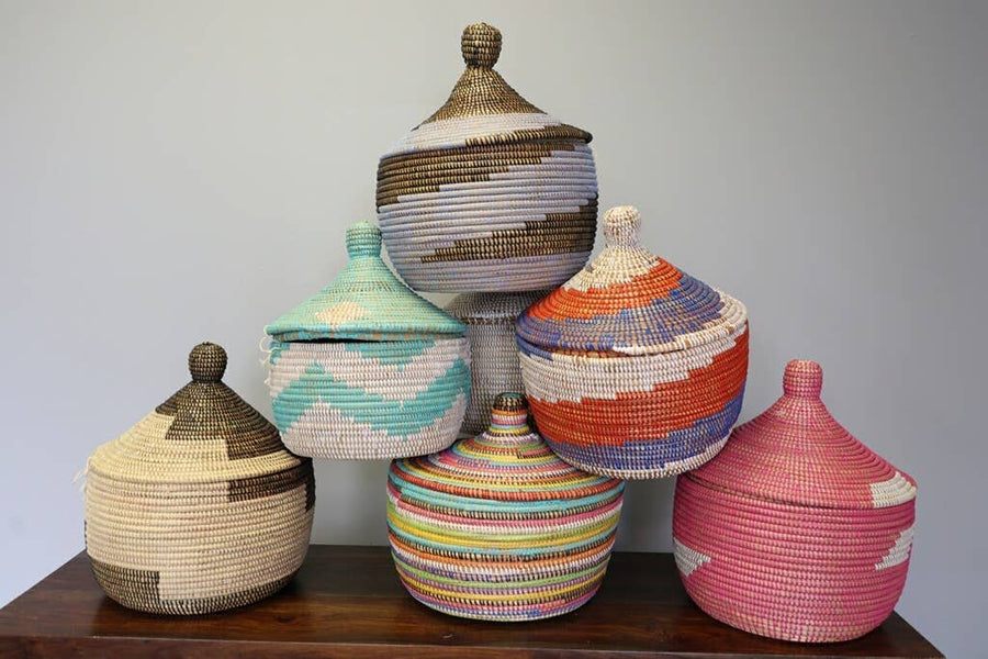 A set of bold rainbow block lidded basket made from sweet grass and recycled plastic in Senegal.
