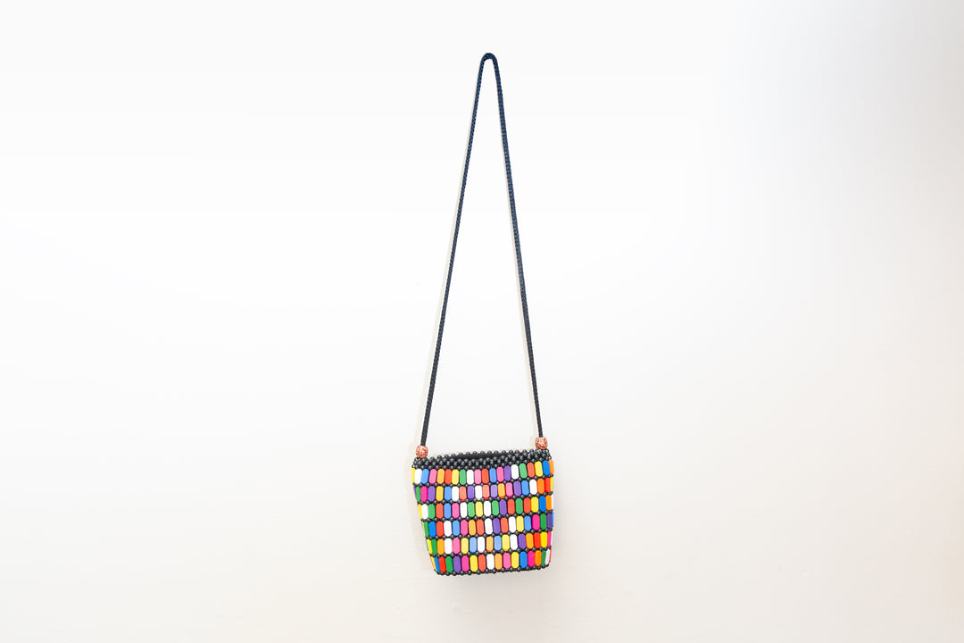 Fair-trade, rainbow colored crossbody purse with wood details that is handmade by artisans in Africa. 