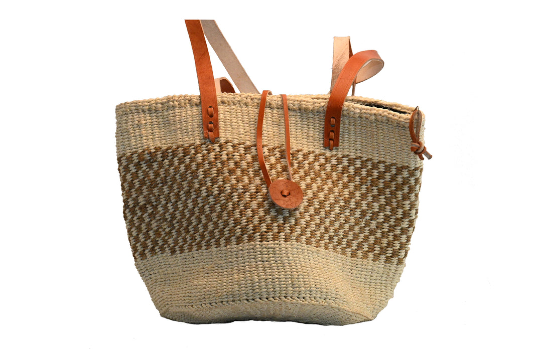 Woven sand colored basket bag with leather handles on a white background