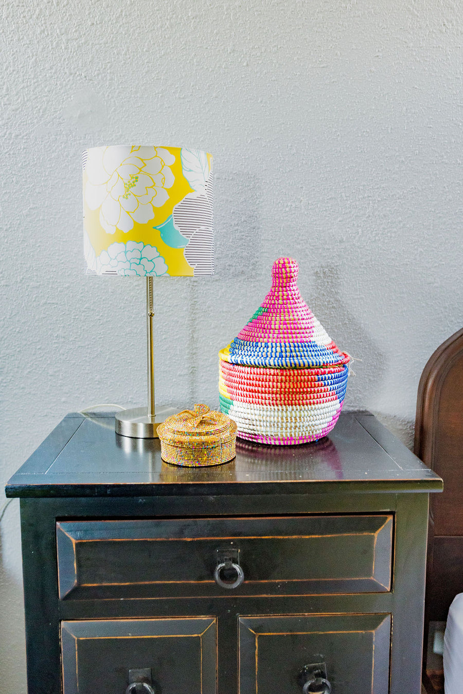Small handwoven basket with lid made from sweet grass and repurposed plastic.