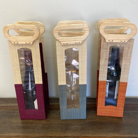Handwoven raffia wine tote in assorted colors.
