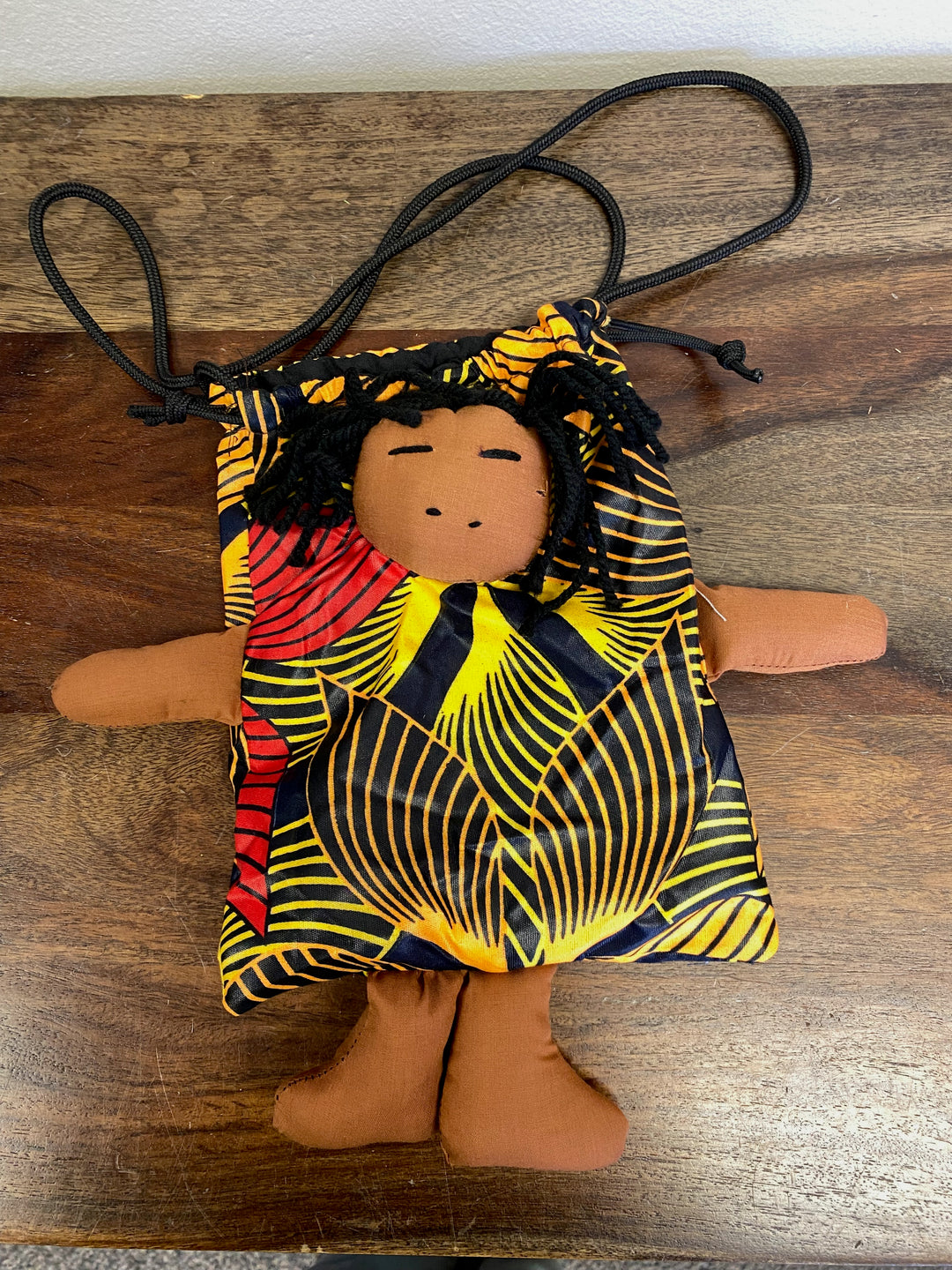Children’s crossbody bag with soft fabric and an attached doll, handcrafted by Kenyan artisans.