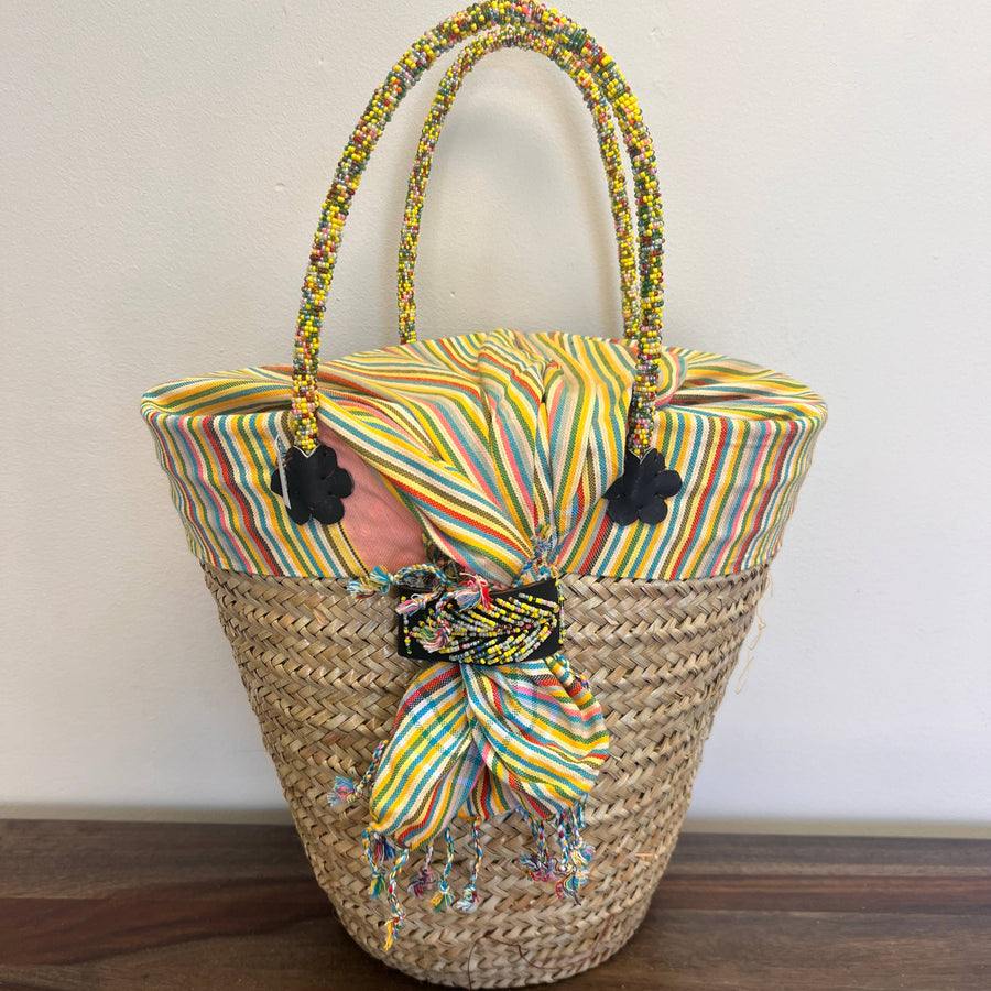 Ethical artisan basket with beaded handles and bright fabric.