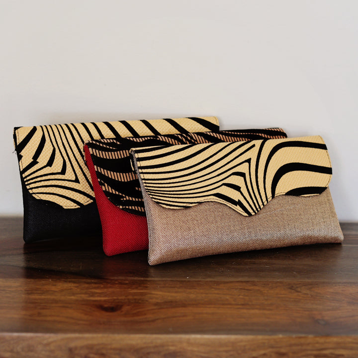 Assorted African print clutch purses displayed together in multiple patterns and colors