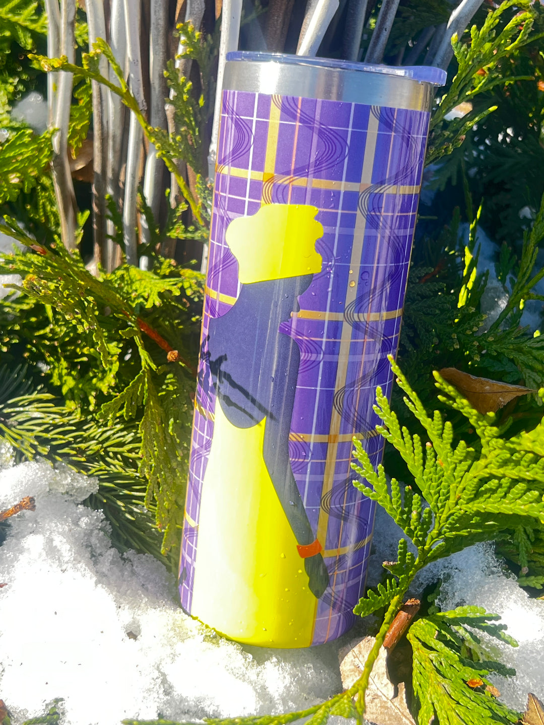 African printed tumbler with purple and yellow design in a snowy outdoor setting