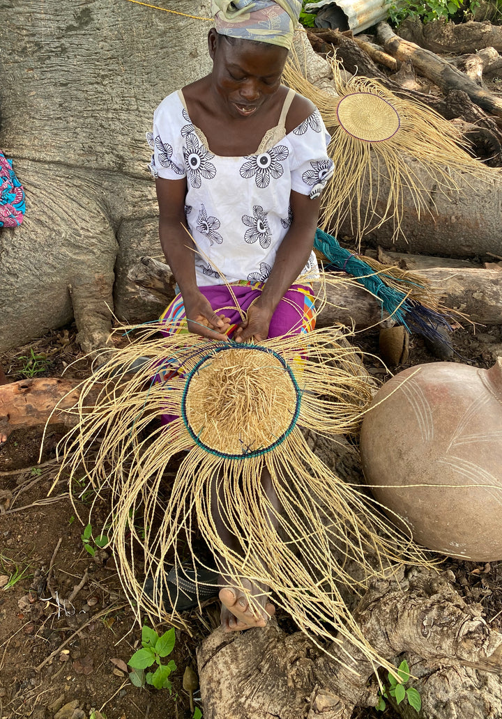 Fair-trade artisan in Africa making a U-shopper basket.