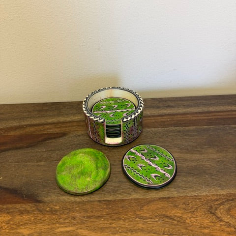 Artisan-made soapstone coasters stacked in holder highlighting green tones.