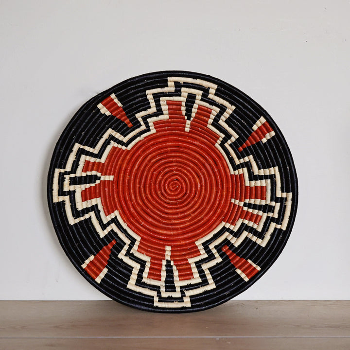 Top view of handwoven Autumn Art bukedo and raffia basket with rust red, black, and natural geometric pattern.