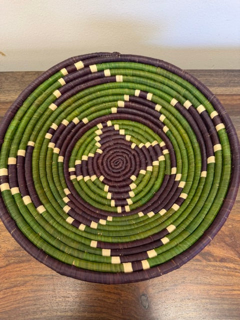 Bright banana leaf stalk and raffia bowl basket woven in Uganda with dyed geometric patterns.
