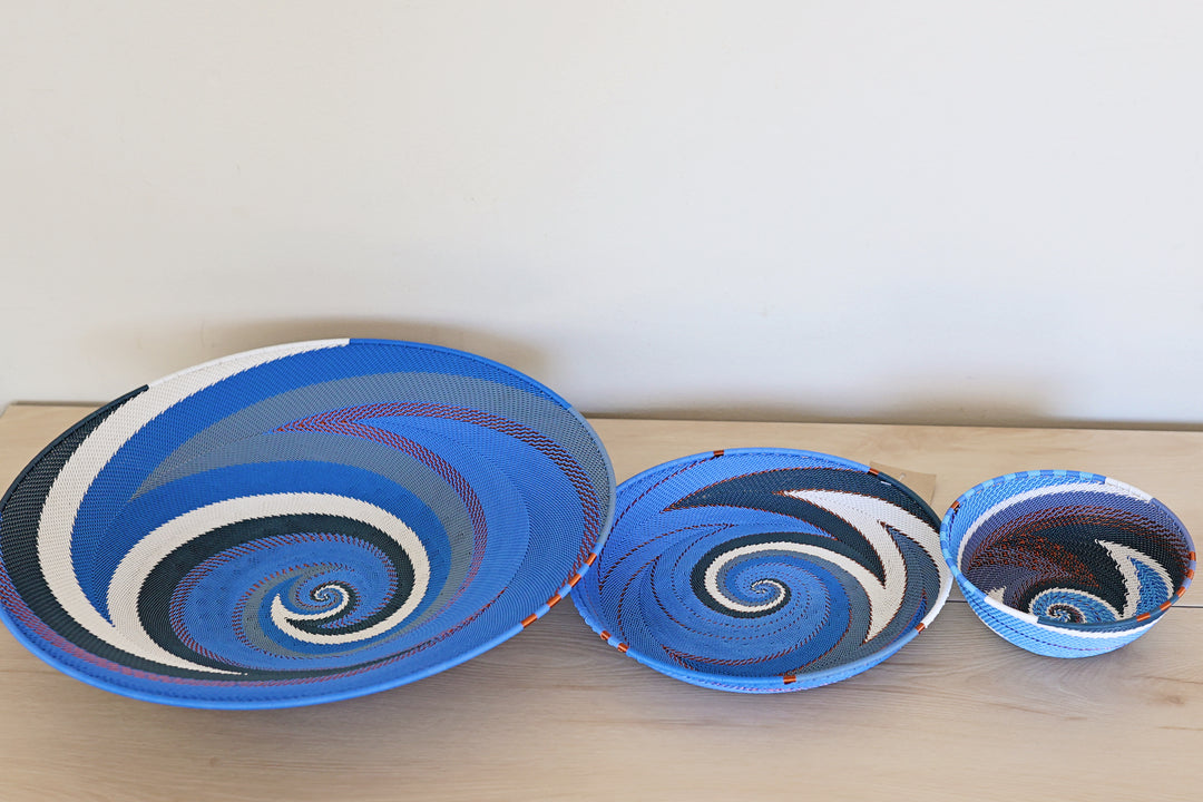 Small Beach Zulu wire basket handwoven in South Africa with a sweeping blue and white spiral pattern.