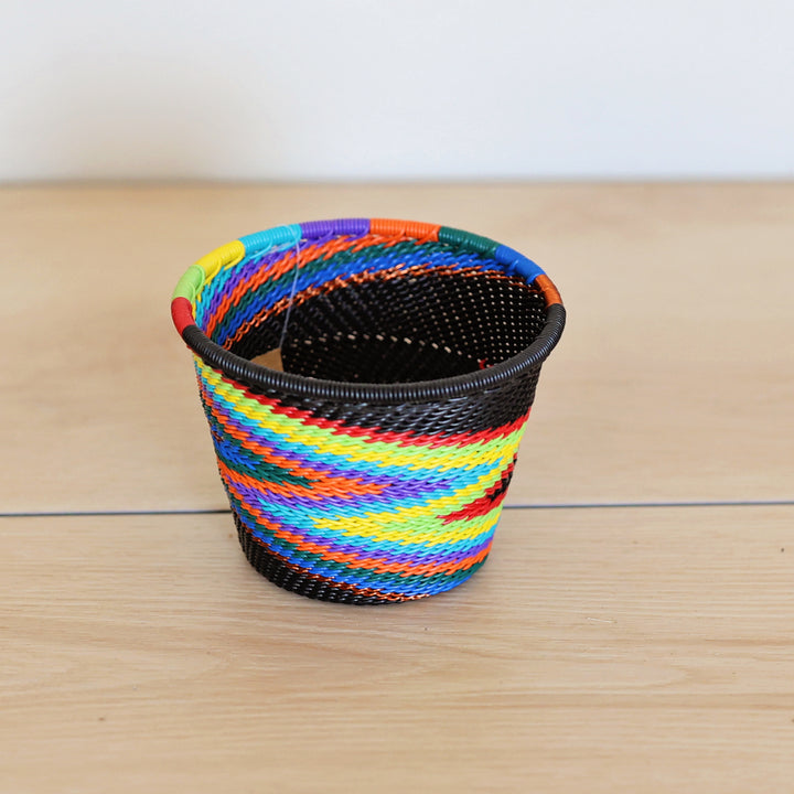 Black Rainbow Zulu Short Cup Basket handwoven in South Africa with colorful diagonal rainbow stripes on a black woven base.