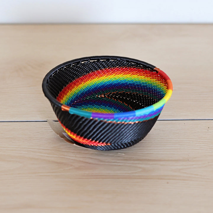 Black Rainbow Zulu Small Bowl handwoven in South Africa with colorful diagonal rainbow stripes on a black woven base.