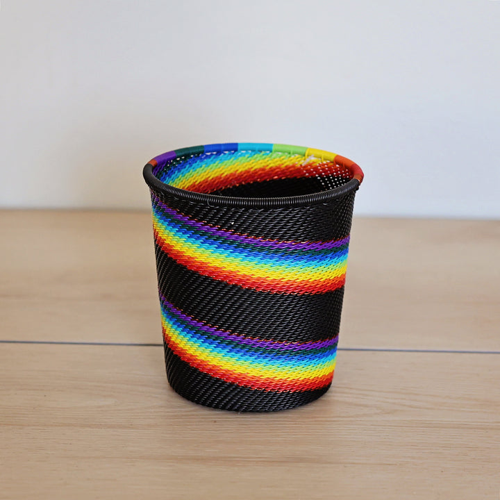 Black Rainbow Zulu Wide Base Cup handwoven in South Africa with colorful diagonal rainbow stripes on a black woven base.