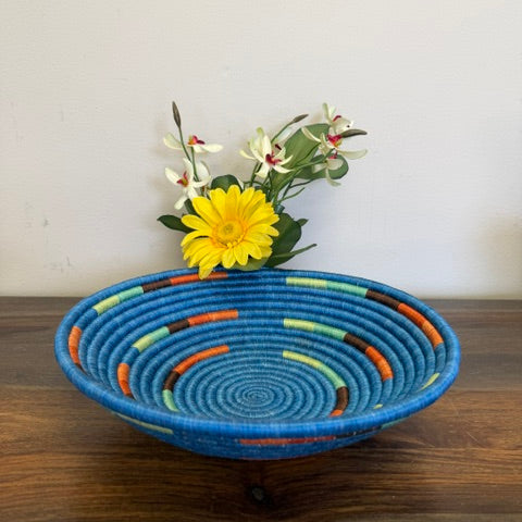 Handwoven Blue Mosaic Rwanda sisal basket featuring rich blue and multicolored geometric patterns viewed from above.